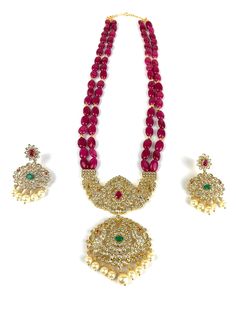 Long mala / haram set in traditional temple style locket with contemporary ruby pink beads. Beautiful pendant and earrings with pearls, CZs, emerald and ruby stones. Very high quality set with premium 24 micron gold plating. Ruby Mala Beads, Hand-set Ruby Temple Jewelry Sets, Ruby Emerald Beads Mala, Luxury Red Ruby Temple Necklace, Traditional Red Mala With Polished Beads, Pearl Mala, Earrings With Pearls, Big Pearl, Indian Necklace