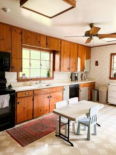 a kitchen with wooden cabinets and white table next to stove top oven, microwave and dishwasher