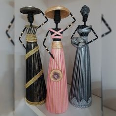 three decorative vases sitting on top of a shelf