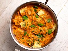 a pan filled with pasta and sauce on top of a wooden table