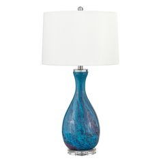 a blue glass table lamp with a white shade