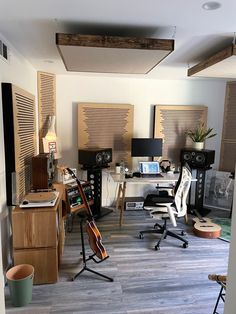 a room filled with lots of furniture and musical equipment on top of hard wood flooring