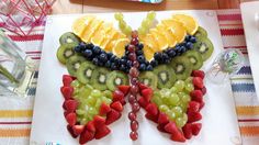 a butterfly made out of fruit sitting on top of a table