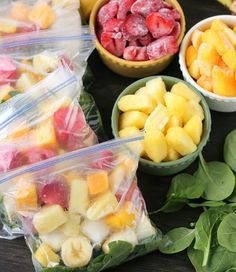 fruits and vegetables are in plastic bags on a table