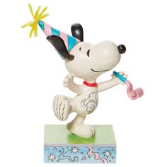 a figurine of a dog wearing a party hat and holding a baseball bat