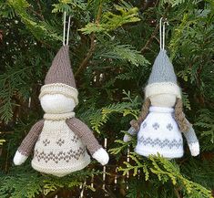 two knitted snowman ornaments hanging from a tree