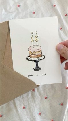 someone holding up a card with a cake on it