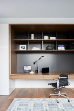 an office area with a desk, chair and bookshelf on the wall above it