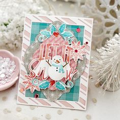 a close up of a snowman card on a table next to some christmas decorations