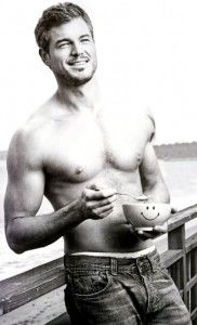 a shirtless man is holding a bowl and smiling at the camera while standing on a pier