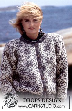 a woman standing next to the ocean wearing a sweater