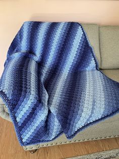 a blue and white blanket sitting on top of a couch