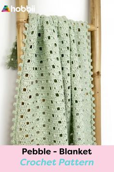 a crocheted blanket is hanging on a wooden rack with the text pebble - blanket crochet pattern