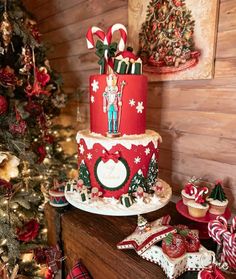 a christmas cake with candy canes and decorations on the table next to a christmas tree