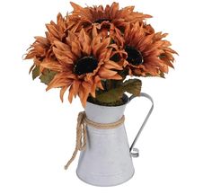 a white vase filled with lots of orange sunflowers