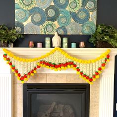 a fireplace decorated with pom poms and garland for the mantel above it