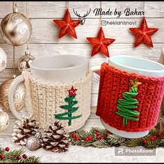 two knitted mug cozyies next to christmas decorations