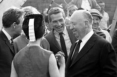 black and white photograph of men in suits talking to each other at an air port event