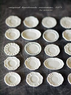 many white plates sitting on top of a black countertop next to eachother