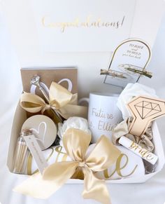 a gift box filled with lots of different types of personal care items and wrapped in gold ribbon