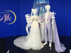 a couple of mannequins dressed in white and purple outfits standing next to each other