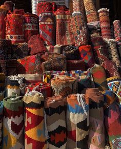 many bags and rugs are stacked on top of each other