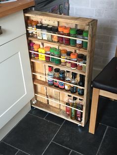 a wooden spice rack in the corner of a kitchen