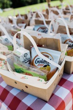 baskets filled with snacks sitting on top of a checkered table cloth covered tablecloth