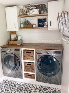 a washer and dryer in a laundry room with white cabinets, black and white tile floor