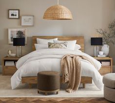 a bed with white sheets and pillows in a bedroom