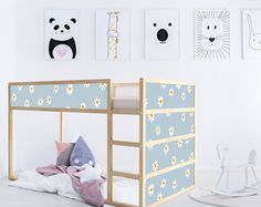 a child's bedroom with a bunk bed and various pictures on the wall above it