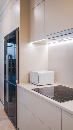 a modern kitchen with white cabinets and appliances