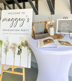 there is a sign that says, welcome to maggy's graduation party on the table