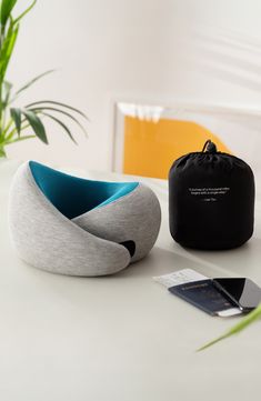 two pieces of furniture sitting on top of a white table next to a potted plant