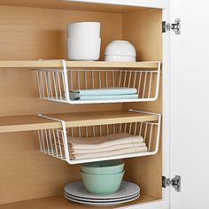 two shelves with dishes and cups in them