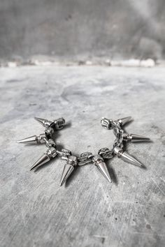 Snake vertebrae cast in metal, set between large spikes. Made with a unique flexible design, this spiked bracelet can flex to contour around your wrist.Suitable for men and women, it fits between a 6.5" on the tightest setting and 8" on the loosest setting.If you need a different size range, specify when ordering.CURRENTLY MADE TO ORDERhttps://v.etsystatic.com/video/upload/ac_none,du_15,q_auto:good/video_new_DNB_17_1_webbjj.mp4 Silver Punk Bracelets With Spikes, Punk Metal Bracelets With Studs, Adjustable Metal Bracelets With Spikes, Rock Style Metal Bracelet With Spikes, Gothic Metal Bracelets With Spikes, Edgy Metal Jewelry With Spikes, Rock Style Metal Bracelets With Studs, Gothic Silver Stud Jewelry, Gothic Silver Jewelry With Studs