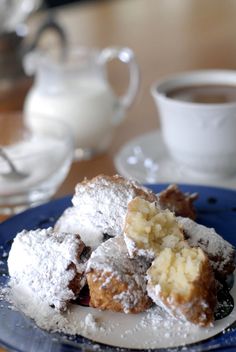 powdered sugar covered doughnuts on a blue plate