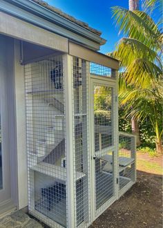 a white bird cage sitting on the side of a building