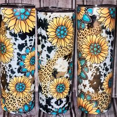 three vases with sunflowers painted on them sitting on a wooden table next to each other