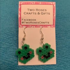 two roses crafts and gifts earrings with facebook logo on the front, green heart shaped dangle