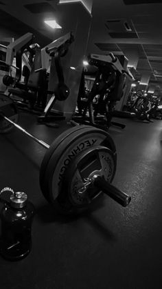 an empty gym room with weight machines and dumbbells in black and white photo