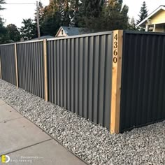 a long metal fence with numbers on the top and bottom posts in front of it