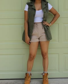 a woman standing in front of a garage door with her hands on her hips and looking at the camera