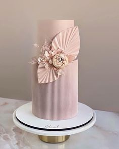 a pink and white cake with flowers on top