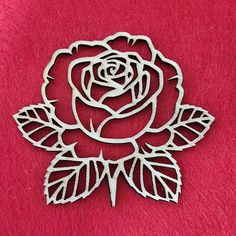 a metal rose with leaves on a red background, cut out in the shape of a flower