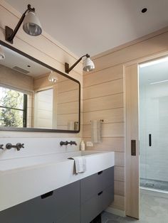 a bathroom with two sinks and a large mirror on the wall next to a walk in shower