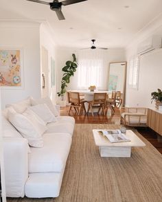 a living room filled with furniture and a large white couch in front of a table