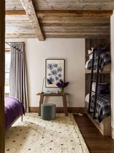 a bed room with a neatly made bed next to a wooden shelf filled with books