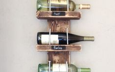 a wooden wine rack with three bottles on it