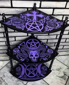 three tiered shelf with purple and black designs on it